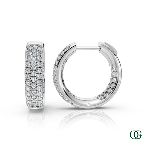W | A pair of white gold inside-out hoop earrings paved with round diamonds, displayed on a clean white background with a soft reflection below. 