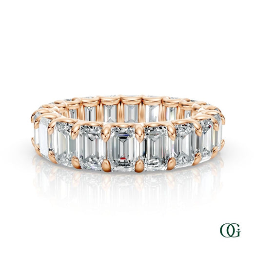 R | A rose gold eternity ring featuring a continuous row of emerald-cut clear diamonds, set against a clean white background with a soft reflection below.