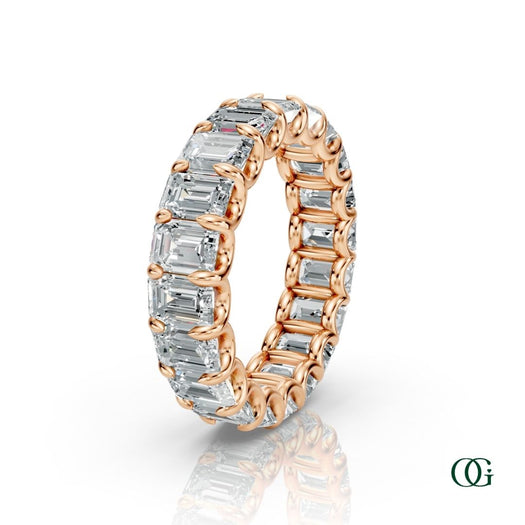 R | A rose gold eternity ring featuring a continuous row of emerald-cut clear diamonds, set against a clean white background with a soft reflection below.