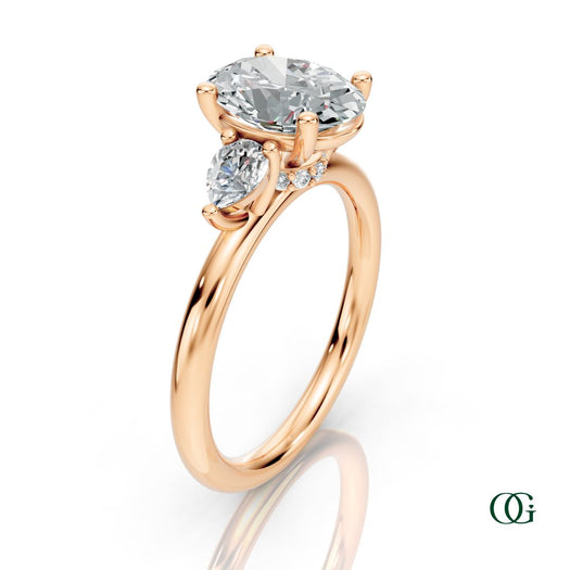 R | A rose gold three-stone engagement ring featuring a large oval-cut center diamond flanked by two marquise-cut side diamonds.