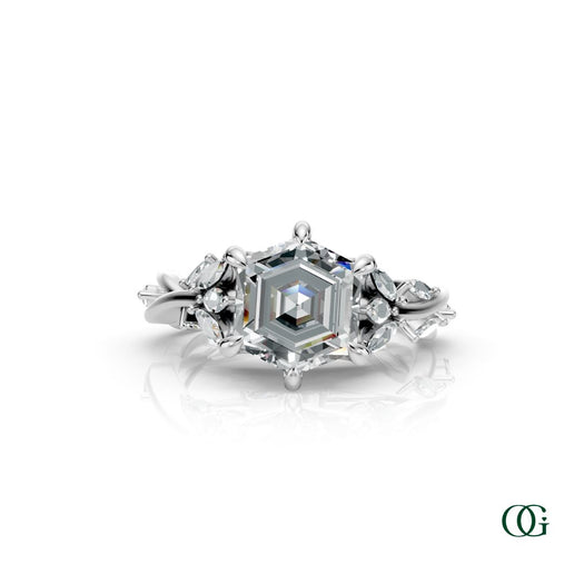 W | A white gold diamond ring featuring a central princess-cut diamond surrounded by smaller round and marquise-cut diamonds, set on a white background with a subtle reflection.