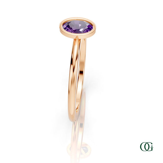 R| A rose gold ring featuring an oval amethyst birthstone for February 