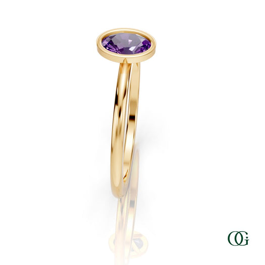 Y| A yellow gold ring featuring an oval amethyst birthstone for February 