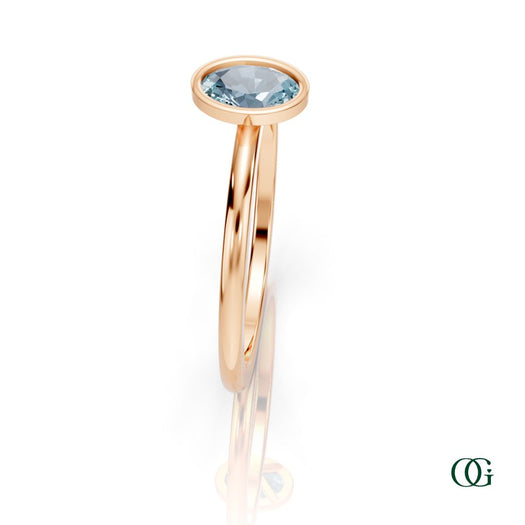 R| A rose gold ring featuring an oval aquamarine birthstone for March