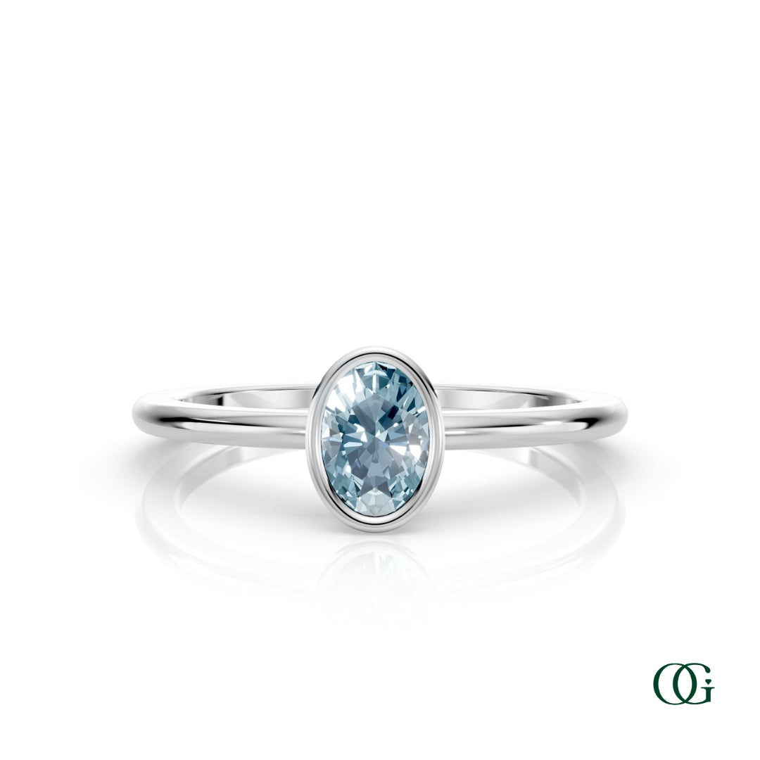 W| A white gold ring featuring an oval aquamarine birthstone for March
