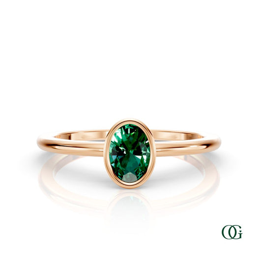 R| A rose gold ring featuring an oval emerald birthstone for May