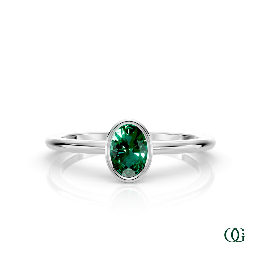 W| A white gold ring featuring an oval emerald birthstone for May