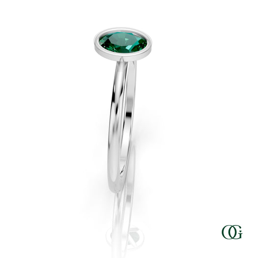 W| A white gold ring featuring an oval emerald birthstone for May