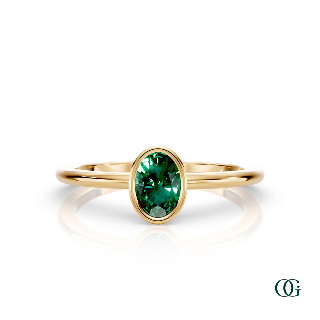 Y| A yellow gold ring featuring an oval emerald birthstone for May