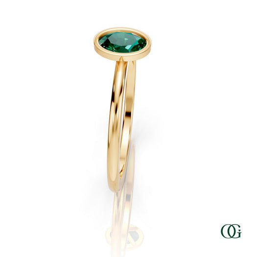 Y| A yellow gold ring featuring an oval emerald birthstone for May