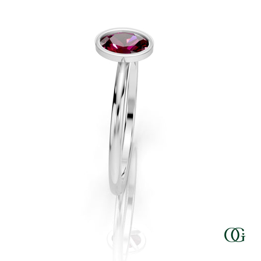 W| A white gold ring featuring an oval garnet birthstone for January
