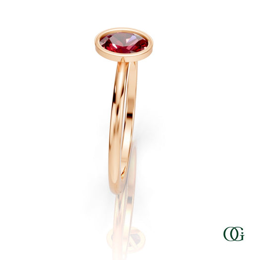 R| A rose gold ring featuring an oval ruby birthstone for July