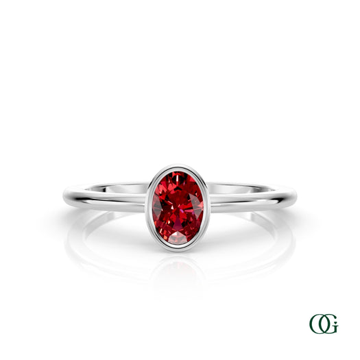 W| A white gold ring featuring an oval ruby birthstone for July