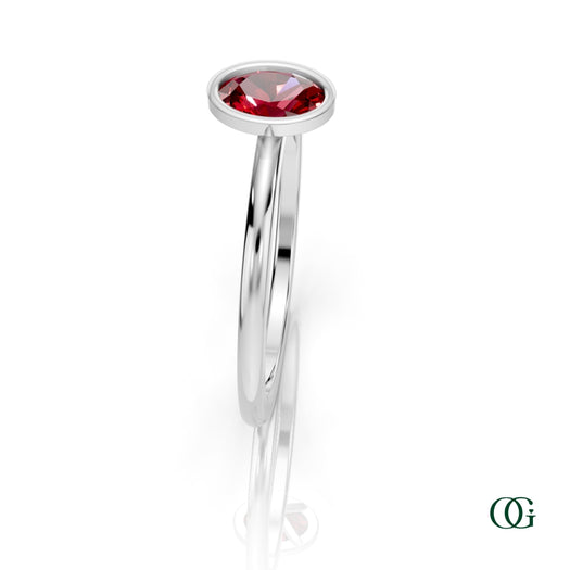 W| A white gold ring featuring an oval ruby birthstone for July