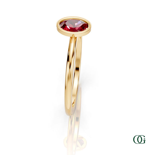Y| A yellow gold ring featuring an oval ruby birthstone for July