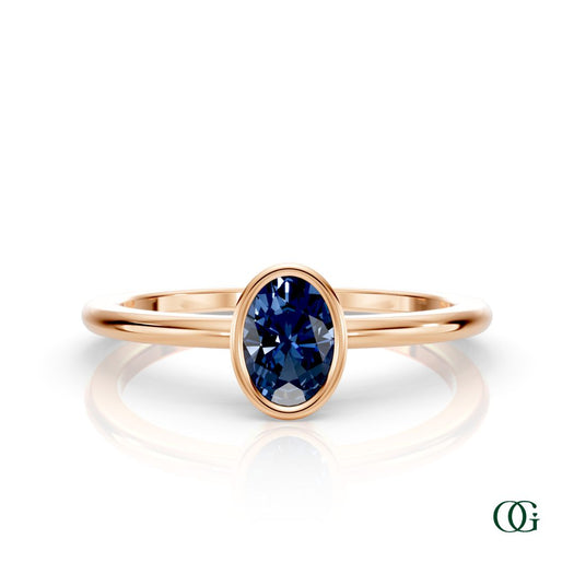 R| A rose gold ring featuring an oval sapphire birthstone for September