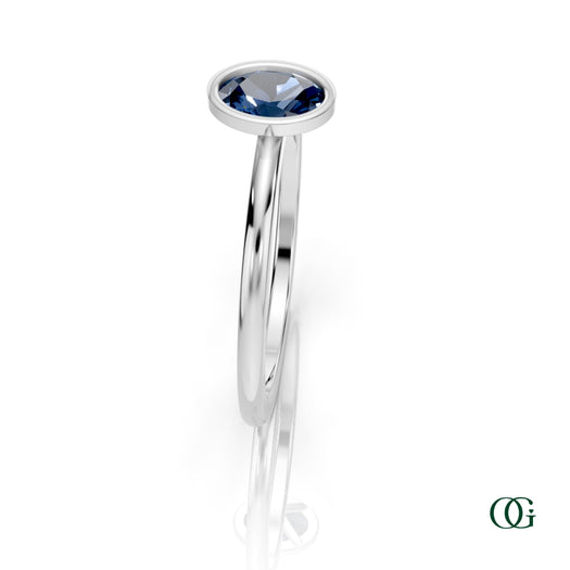 W| A white gold ring featuring an oval sapphire birthstone for September 