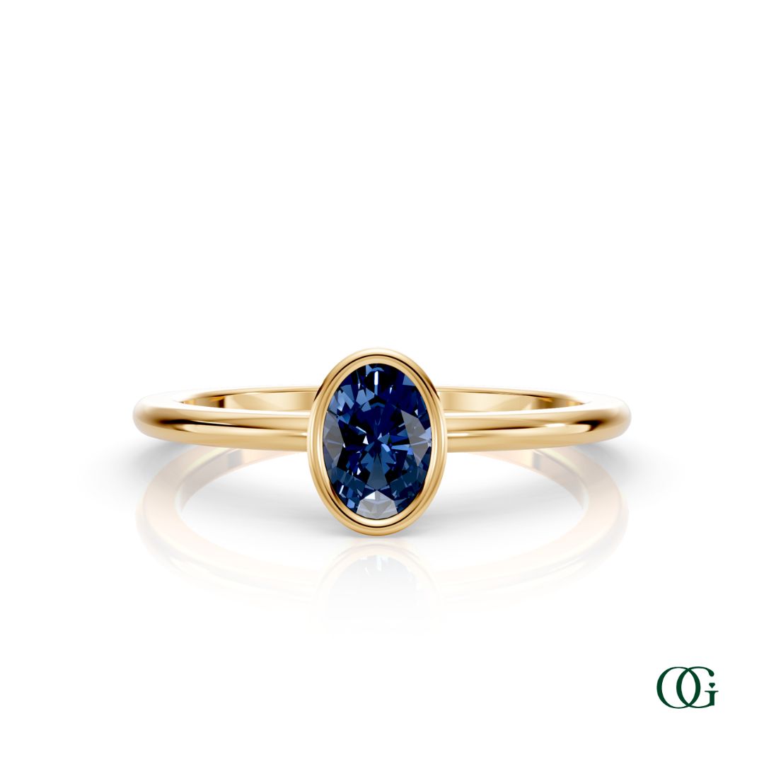 Y| A yellow gold ring featuring an oval sapphire birthstone for September