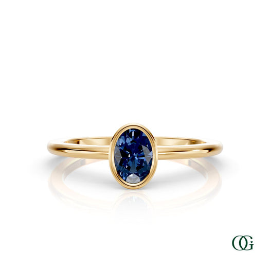 Y| A yellow gold ring featuring an oval sapphire birthstone for September