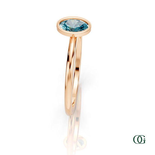 R| A rose gold ring featuring an oval topaz birthstone for December