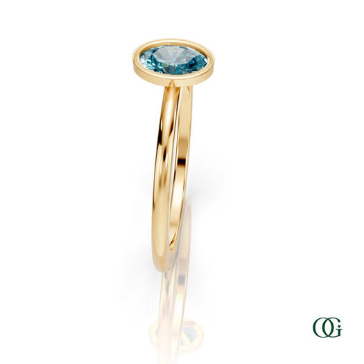 Y| A yellow gold ring featuring an oval topaz birthstone for December