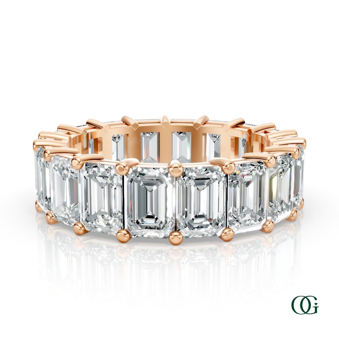 R | A rose gold eternity ring featuring a row of emerald-cut clear diamonds, set against a clean white background with a soft reflection.