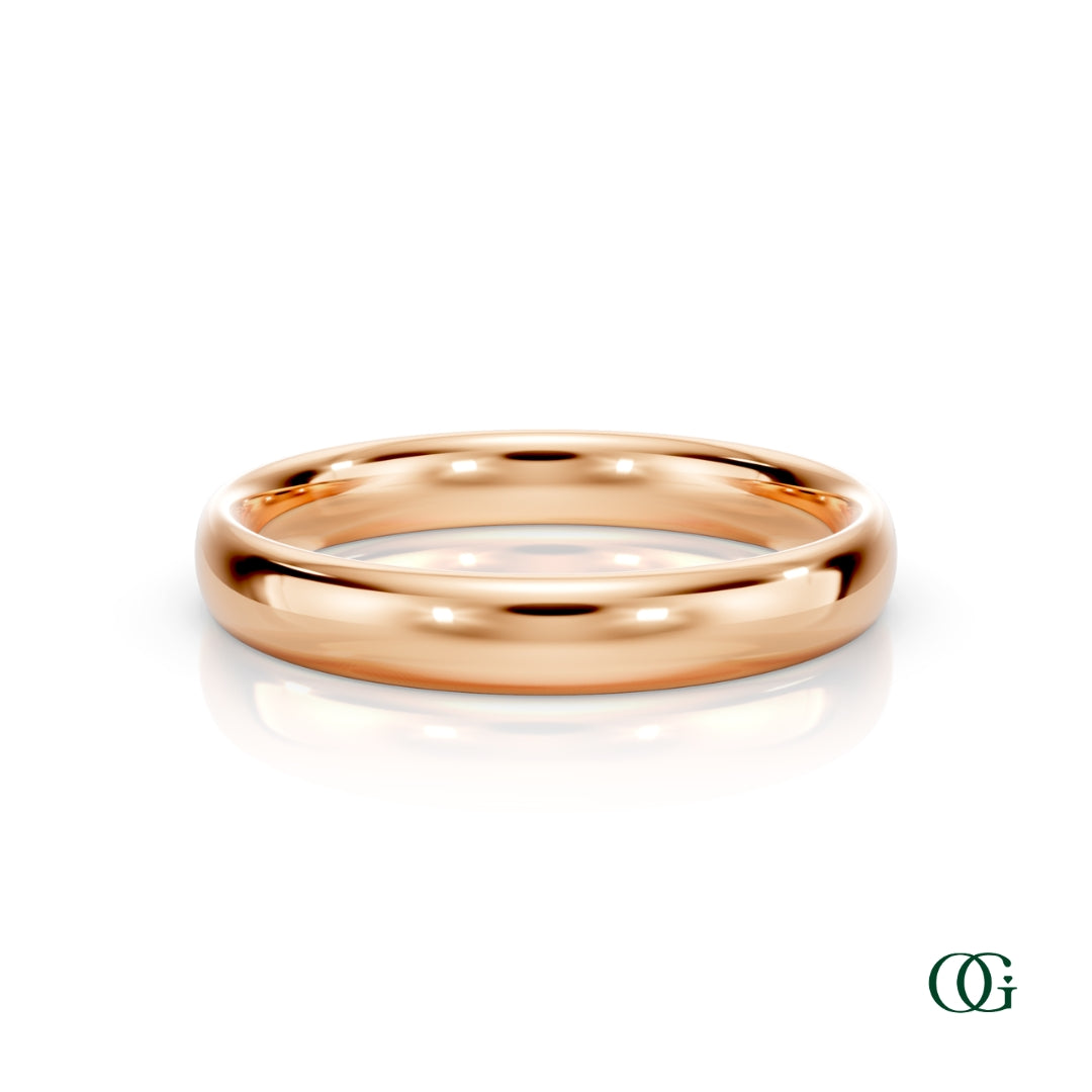R | A polished rose gold wedding band ring standing upright on a white reflective surface.