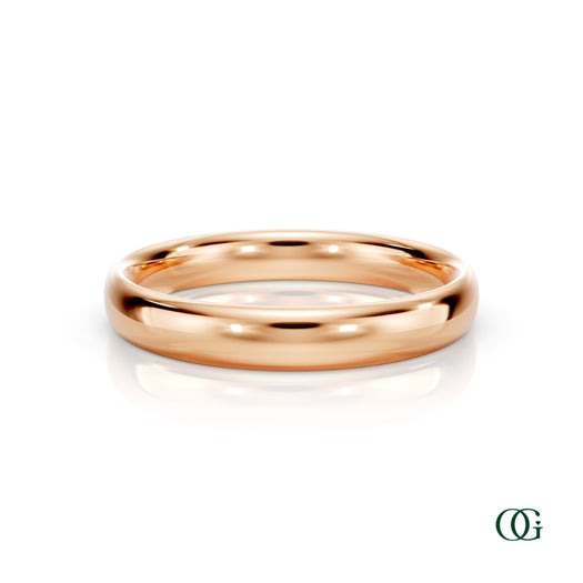 R | A polished rose gold wedding band ring standing upright on a white reflective surface.