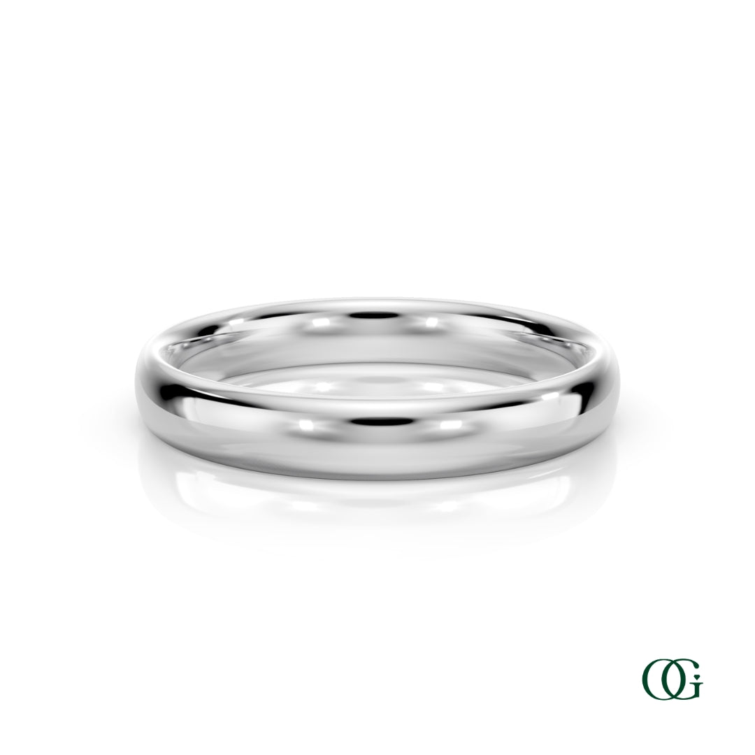 W | A polished white gold wedding band ring standing upright on a white reflective surface.