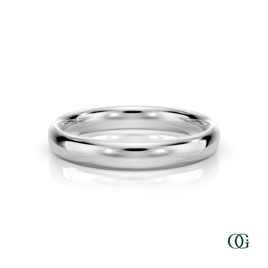 W | A polished white gold wedding band ring standing upright on a white reflective surface.