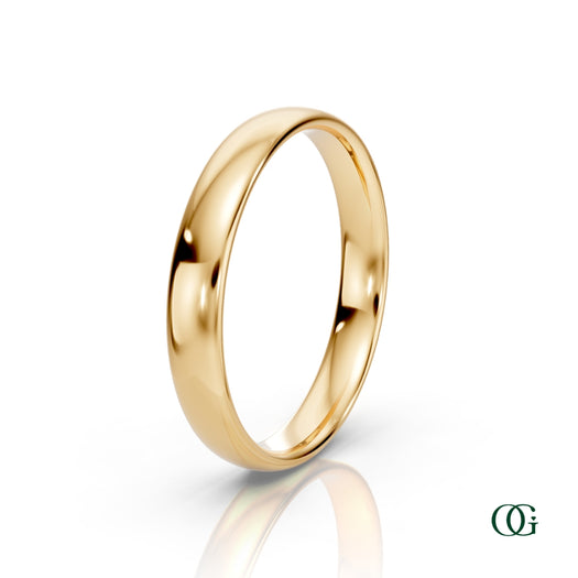 Y | A polished yellow gold wedding band ring standing upright on a white reflective surface.