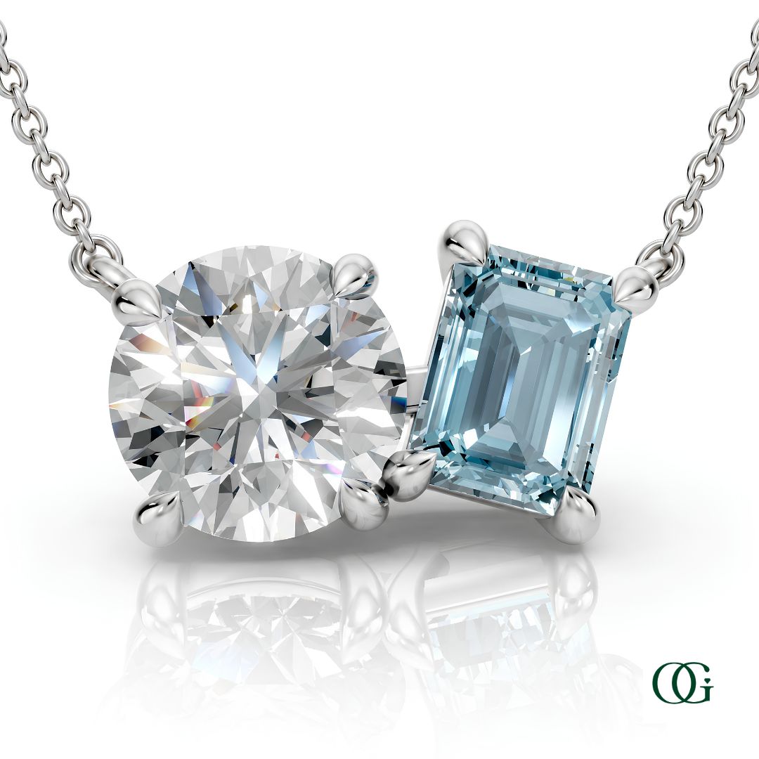 W | white gold necklace with two stones: a round diamond center stone and an  emerald-cut aquamarine side stone.