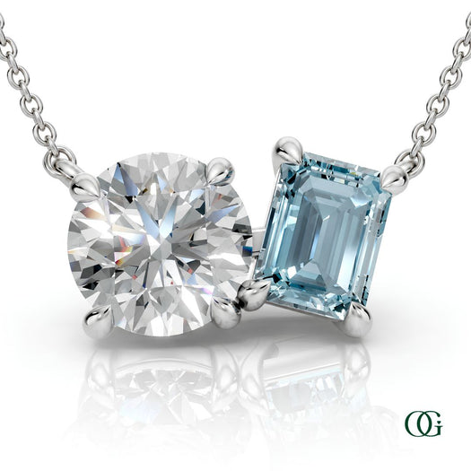 W | white gold necklace with two stones: a round diamond center stone and an  emerald-cut aquamarine side stone.