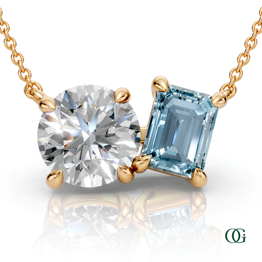 Y | gold necklace with two stones: a round diamond center stone and an  emerald-cut aquamarine side stone.