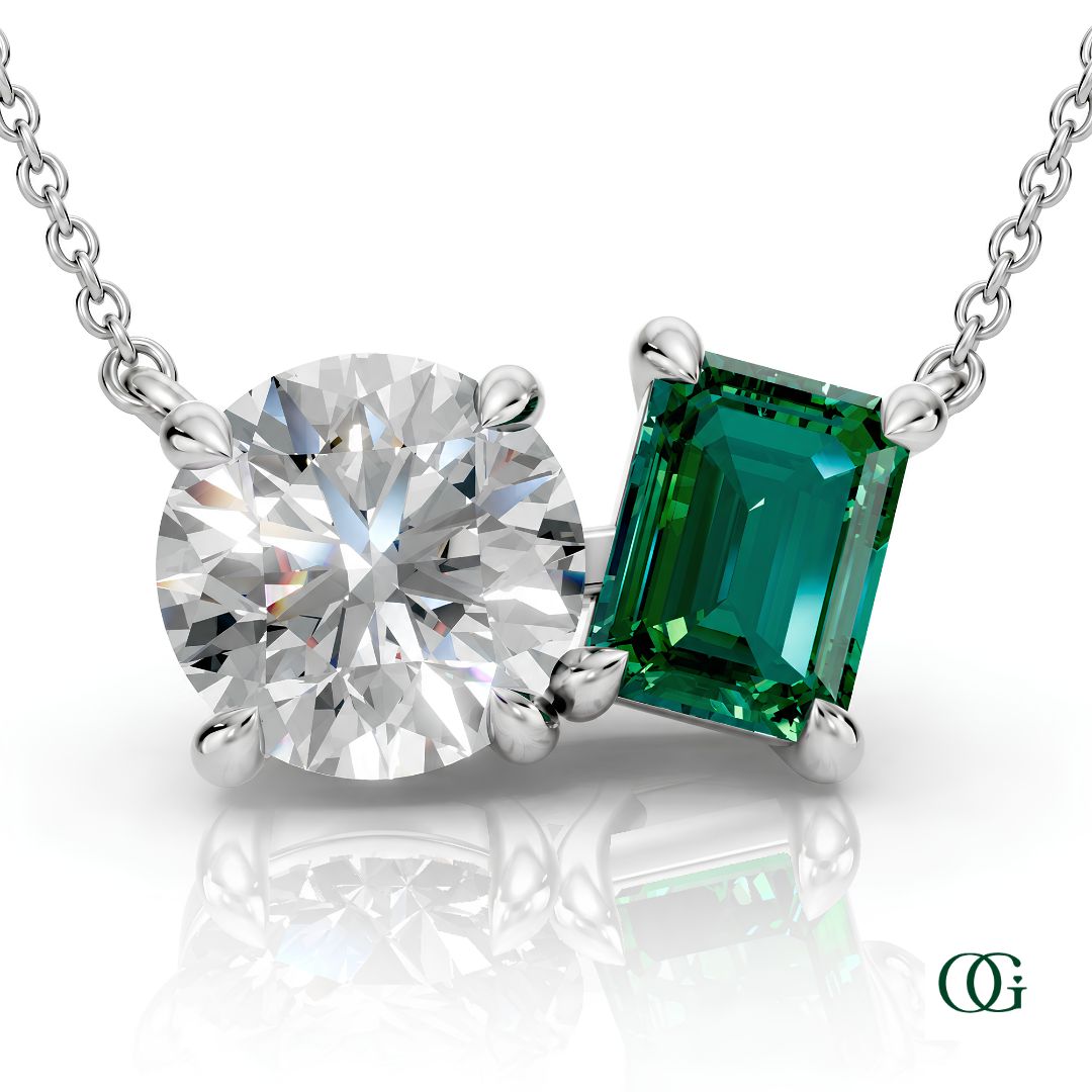 W | white gold necklace with two stones: a round diamond center stone and an  emerald-cut emerald side stone.