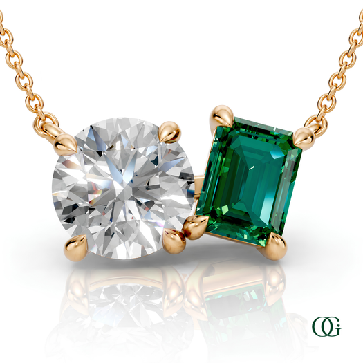 Y | gold necklace with two stones: a round diamond center stone and an  emerald-cut emerald side stone.