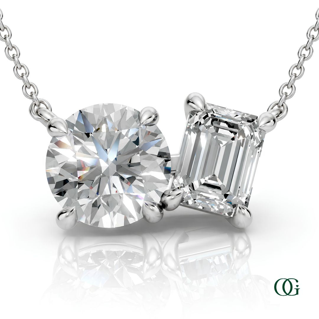 W | white gold necklace with two stones: a round diamond center stone and an  emerald-cut diamond side stone.