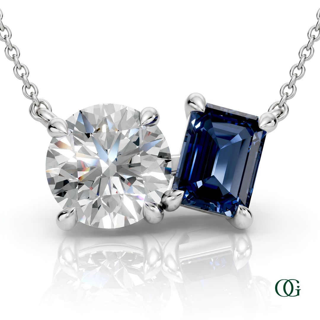 W | white gold necklace with two stones: a round diamond center stone and an  emerald-cut sapphire side stone.